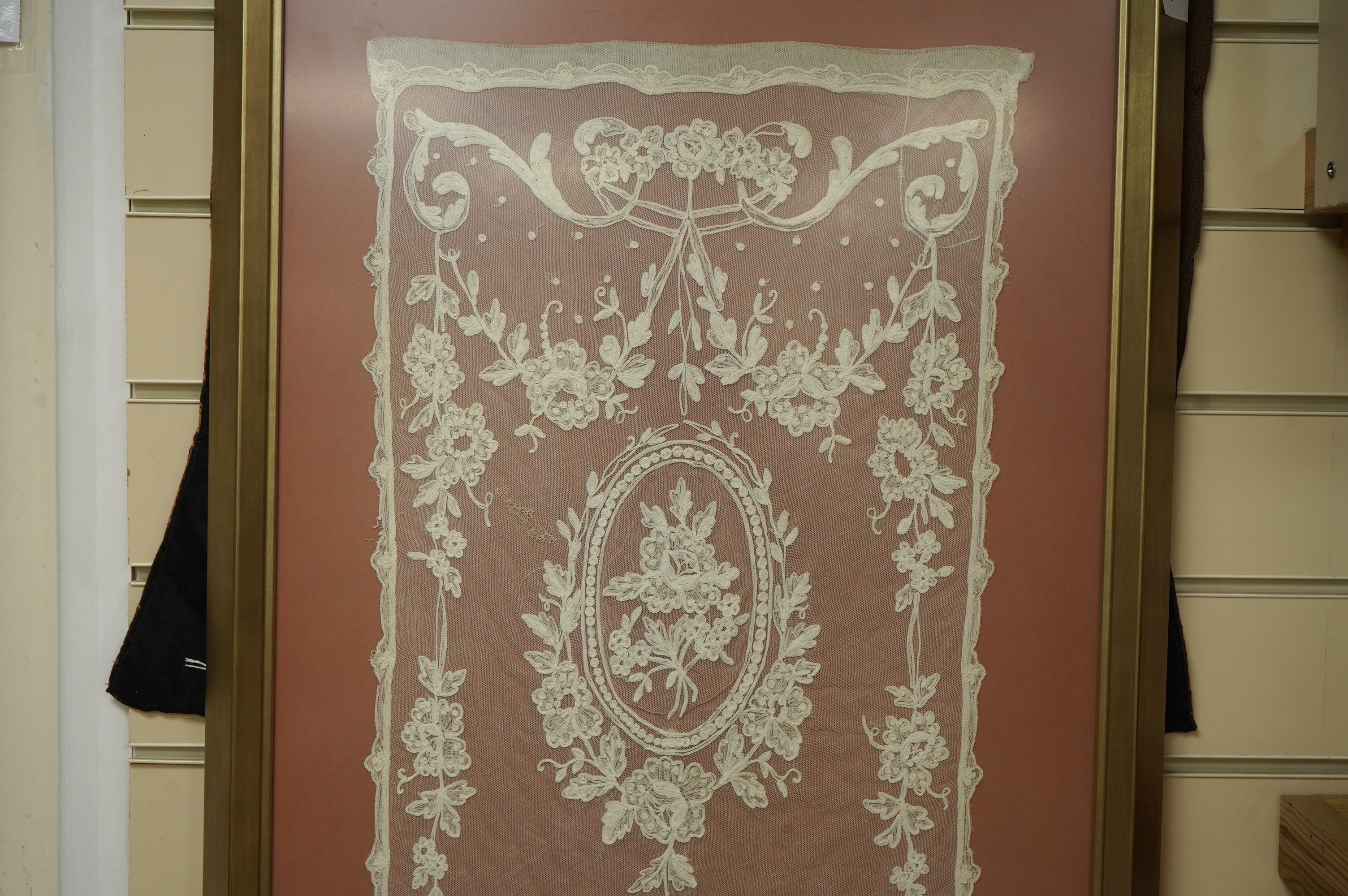 A framed Victorian white work needlerun lace stole with decorative urns and flowers each end, 154cm long x 33cm wide. Condition - has small darns to net one end, otherwise good.